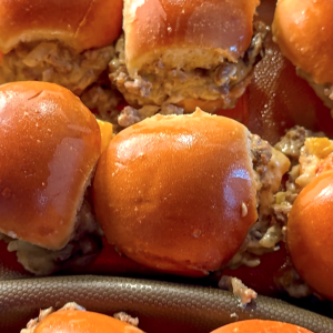 Cheese steak sloppy joes with ground meat, peppers, onions, and melted cheese