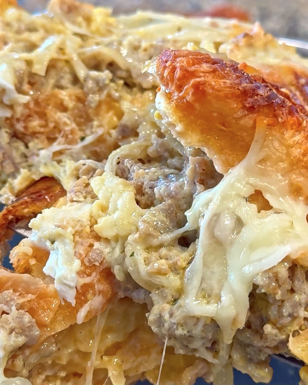Croissant breakfast bake with sausage, onions, cheese, and eggs