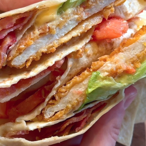 Chicken BLT wrap with crispy bacon, lettuce, tomato, and sauce